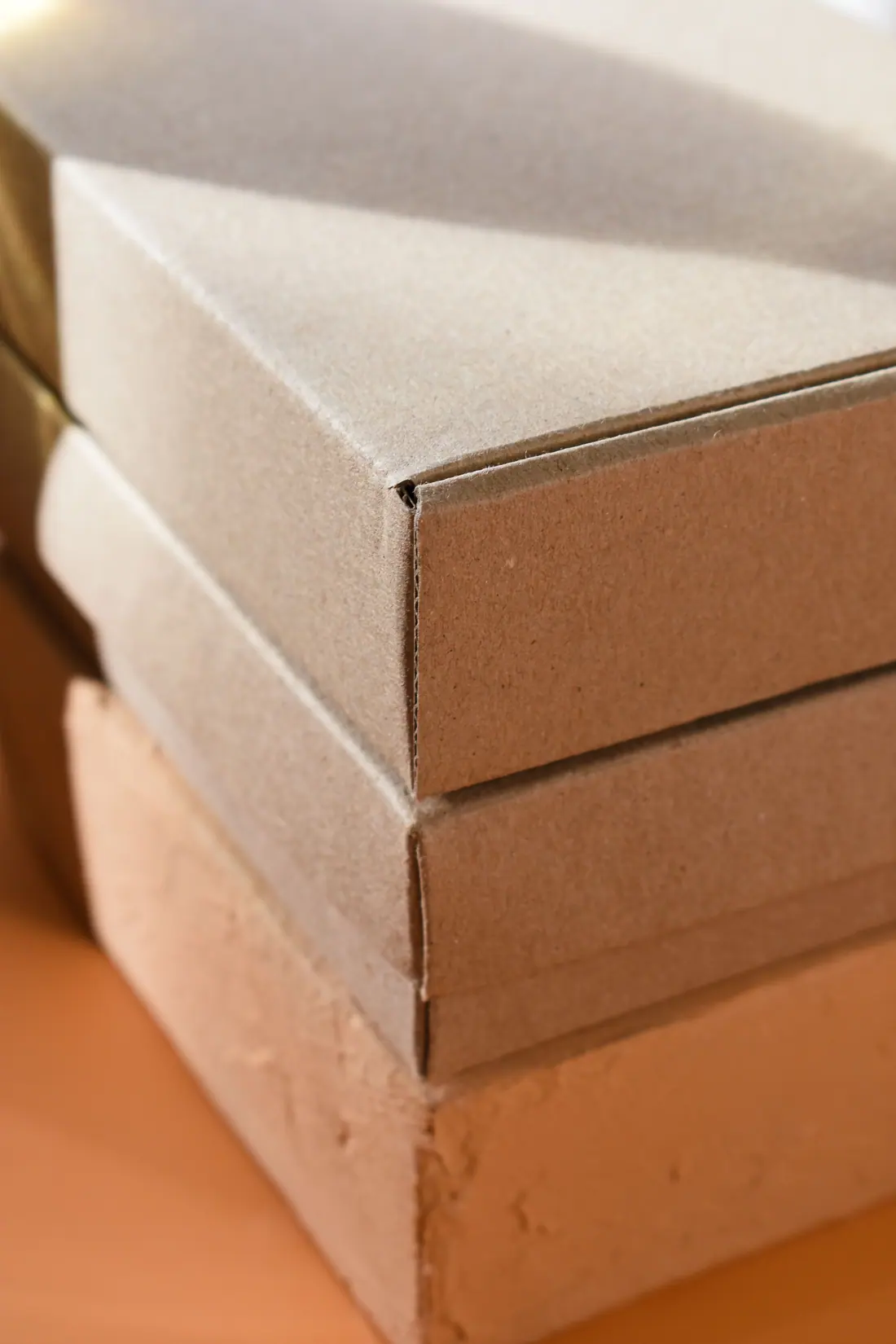 A neat stack of flat brown cartons in warm light.