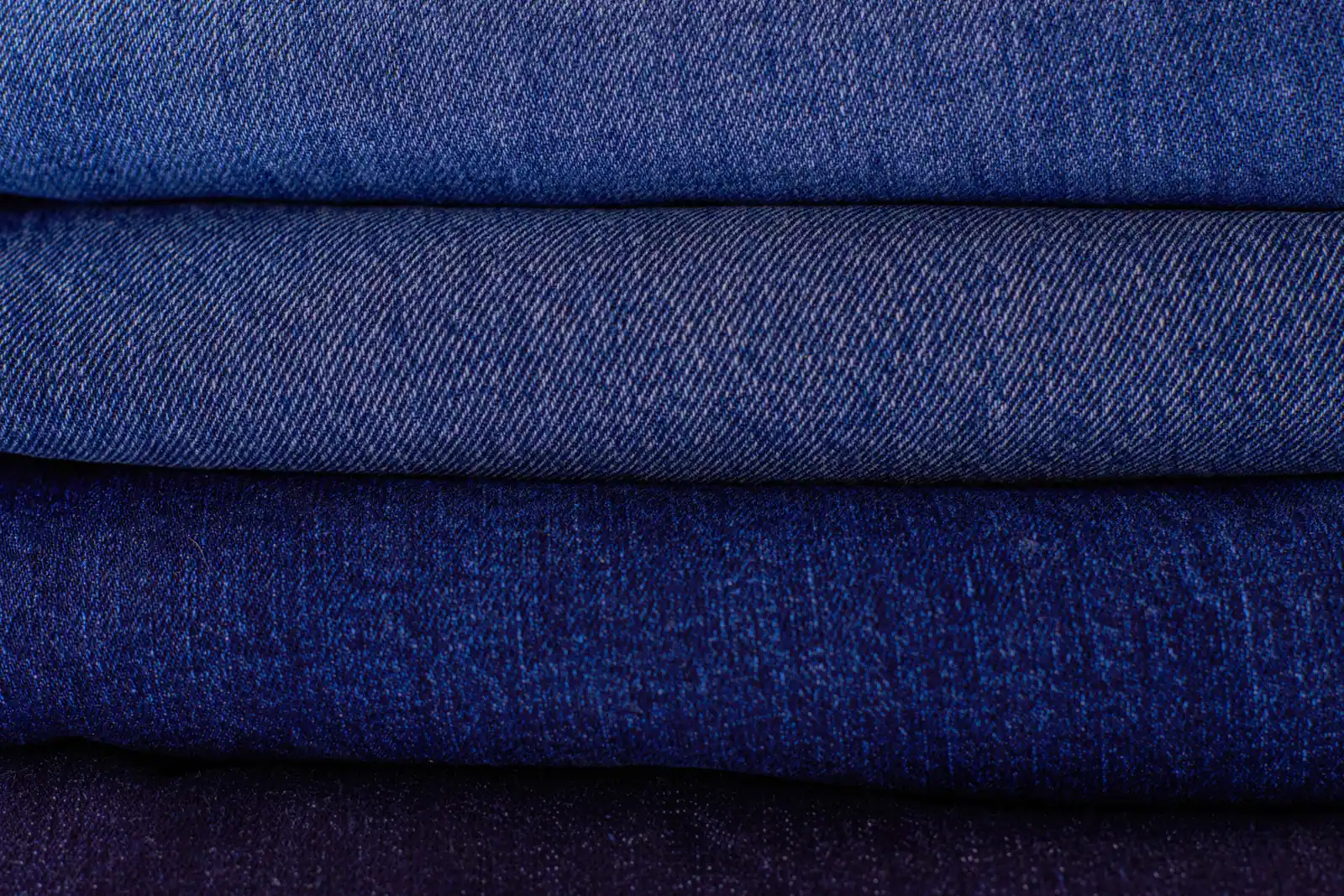 Close stacks of folded indigo denim.