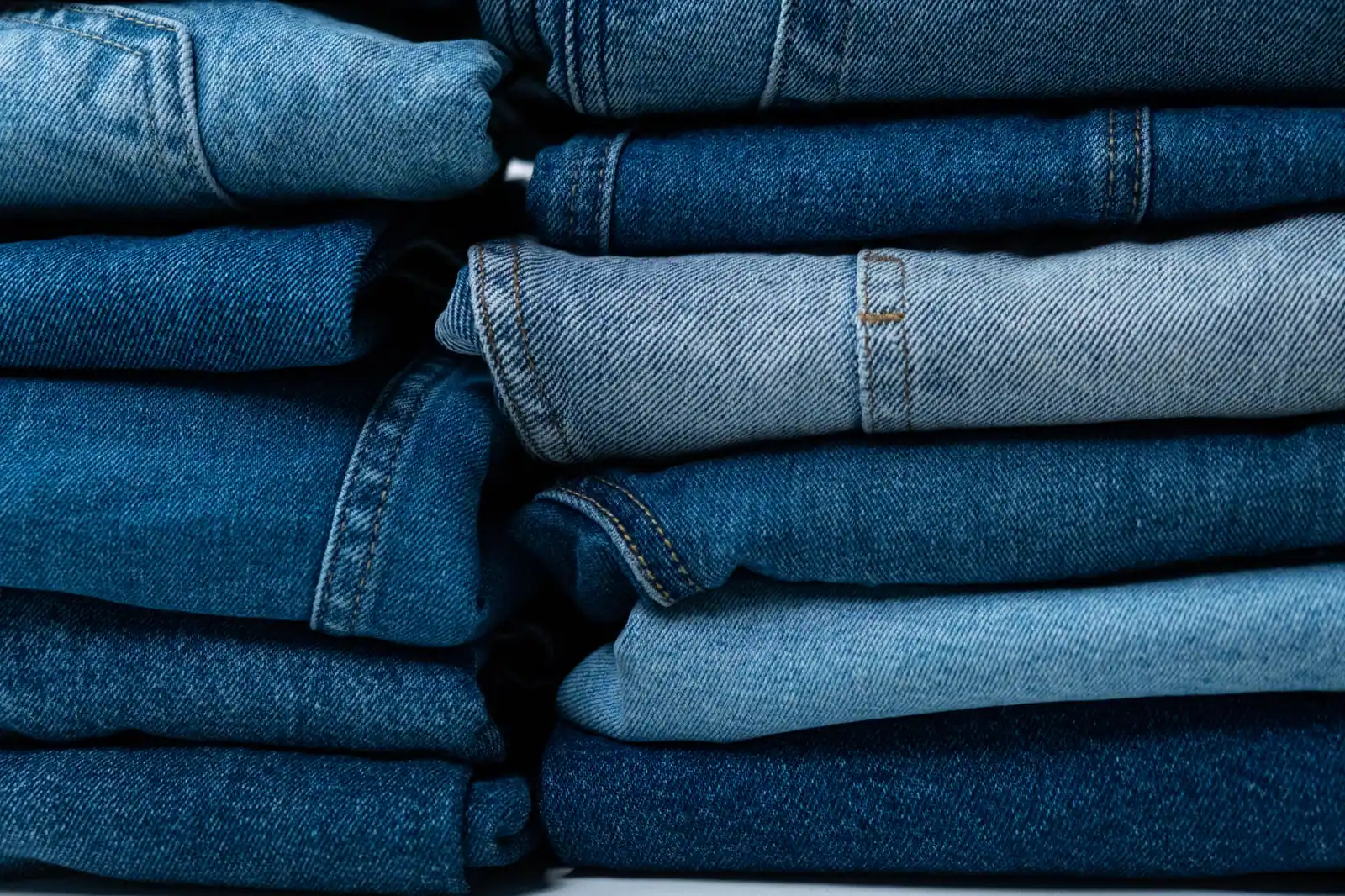 Folded jeans in mixed washes stacked in two columns.